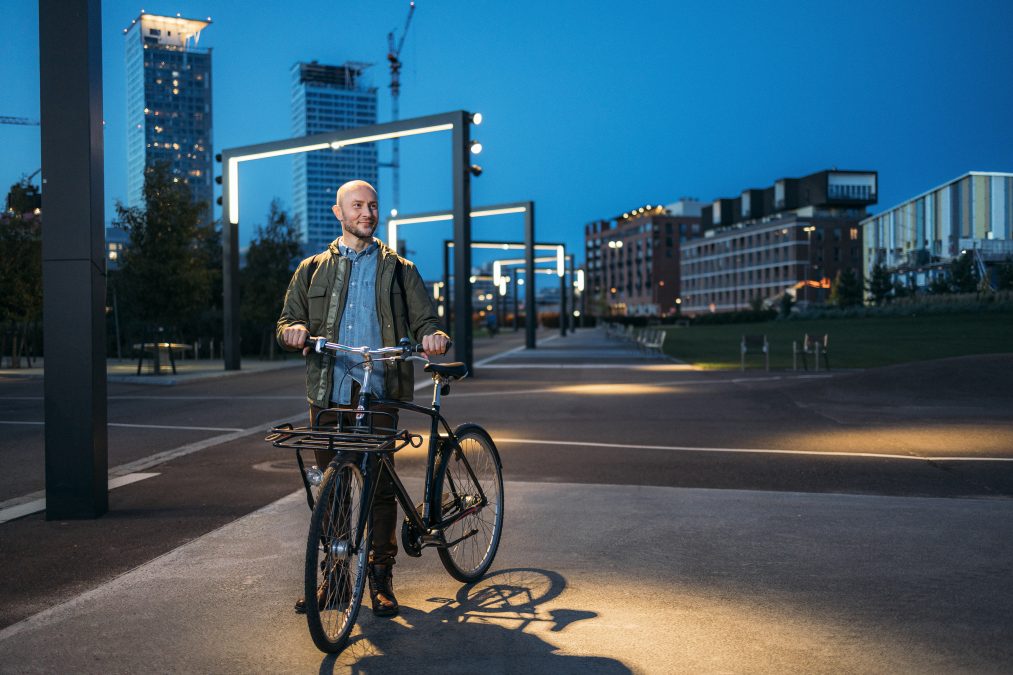 Kuvituskuva: mies taluttaa pyörää Helsingissä.